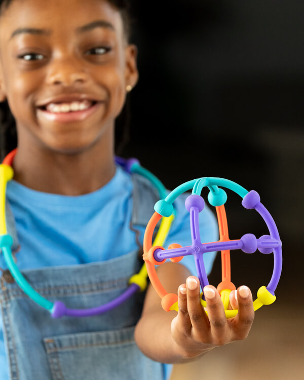 Child smiling and playing with Plip Kit